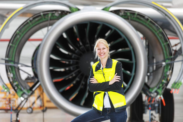 Airbus employee, woman in front of commercial aircraft engine