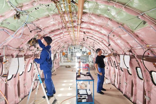 A320 Fal in hangar 214 Blue collars workers in fuselage