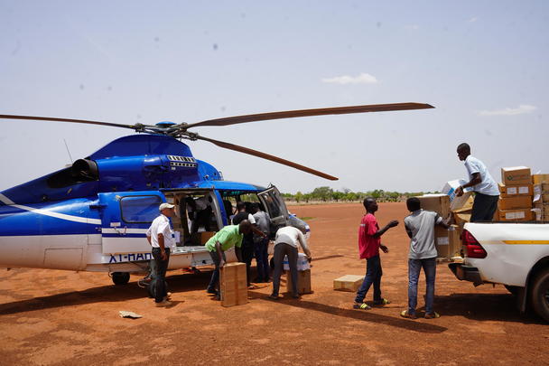People loading cargo into a helicopter
