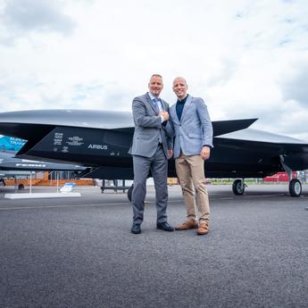 Michael Schoellhorn, CEO at Airbus Defence and Space (on the left), and Gundbert Scherf, Co-CEO at Helsing, in front of the Airbus Wingman model.