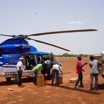 People loading cargo into a helicopter
