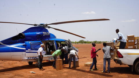 People loading cargo into a helicopter