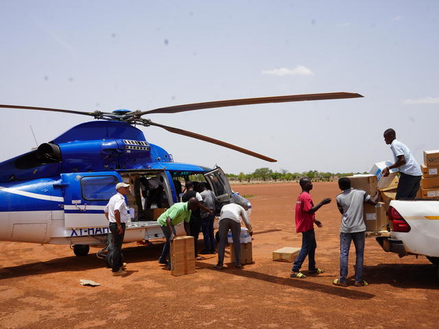 People loading cargo into a helicopter