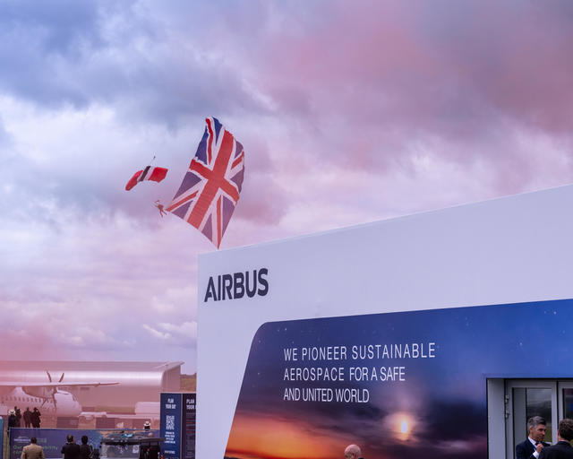 Parachuter in front of the Airbus Pavilion Parachuter with Union Flag in tow drifts to the ground in front of the Airbus pavilion at Farnborough Airshow