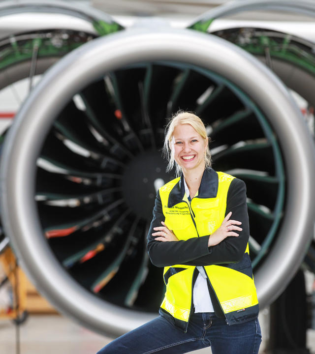 Airbus employee, woman in front of commercial aircraft engine